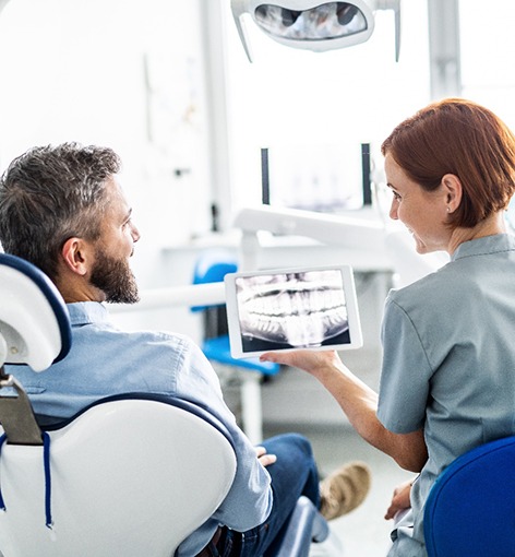 A dentist showing a patient an X-ray
