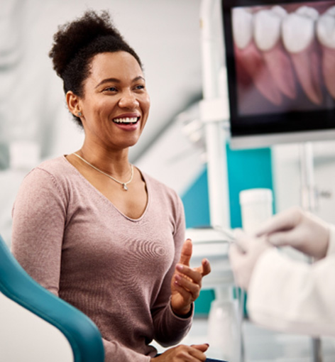 Woman talking to dentist about gum disease treatment in Hayward 
